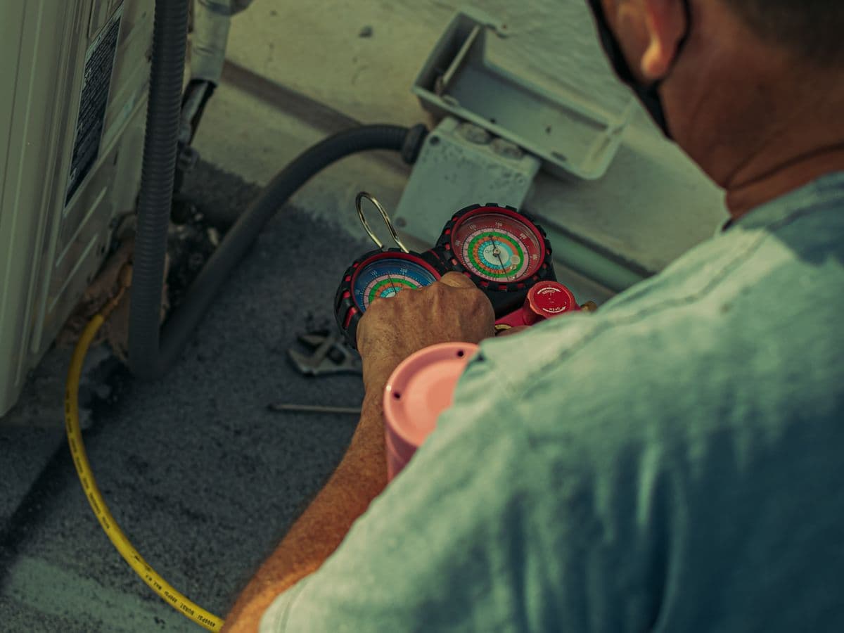 Illustrative photo of a technician checking HVAC equipment with gauges