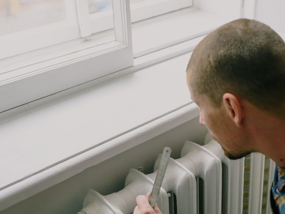 Illustrative photo of a technician measuring a home radiator